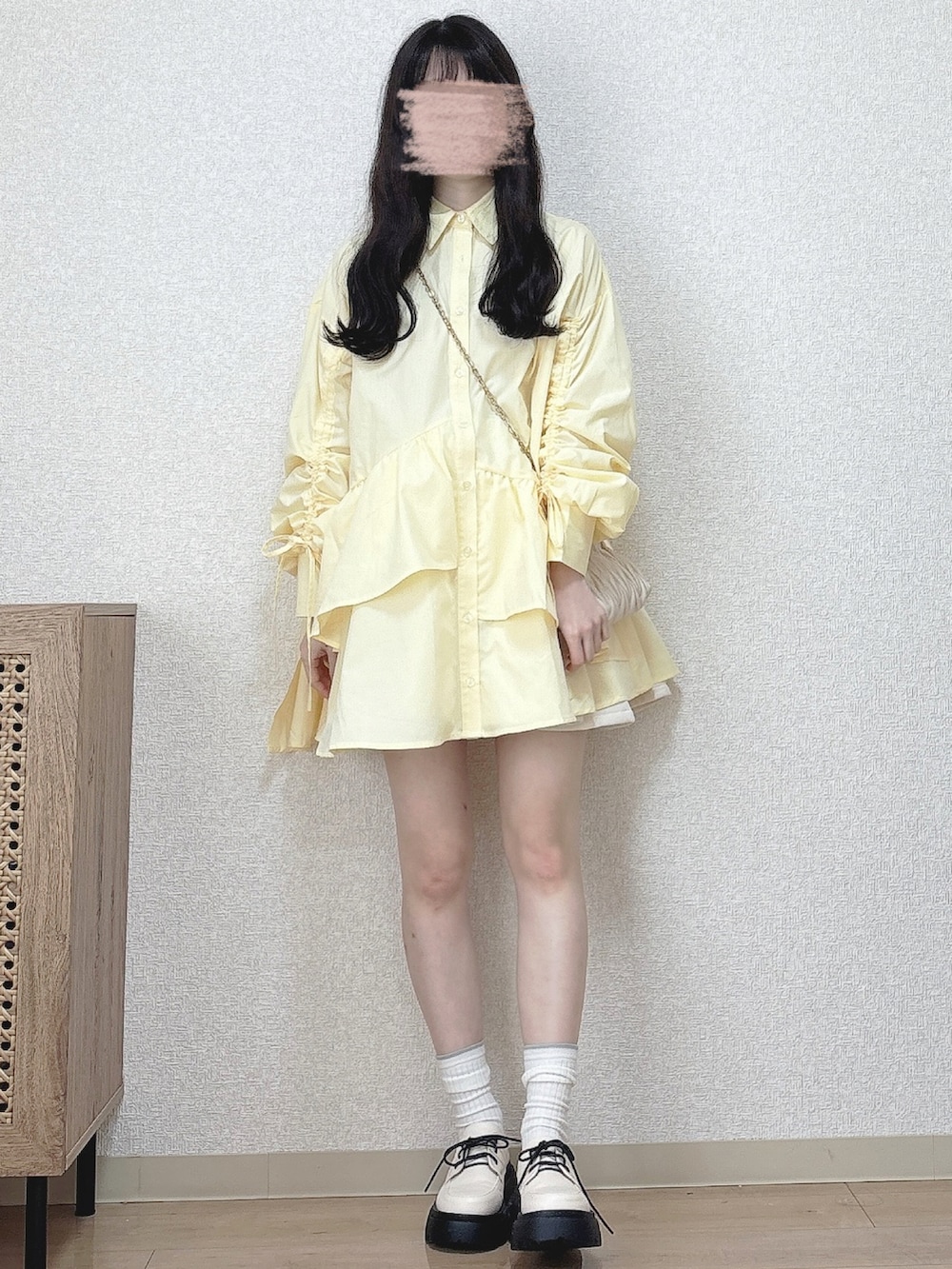 ベージュ系のショルダーバッグ、ホワイト系のパンプスを着用したレディースの冬コーディネートの2枚目の写真