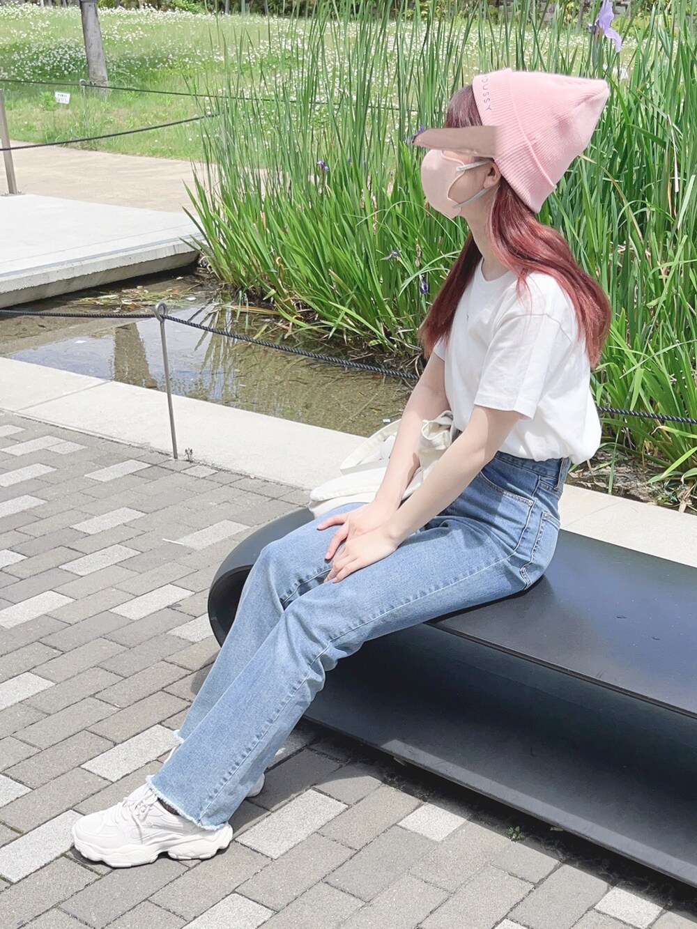 ホワイト系のTシャツ/カットソー、ブルー系のデニムパンツ、ホワイト系のトートバッグを着用したレディースの春コーディネートの2枚目の写真