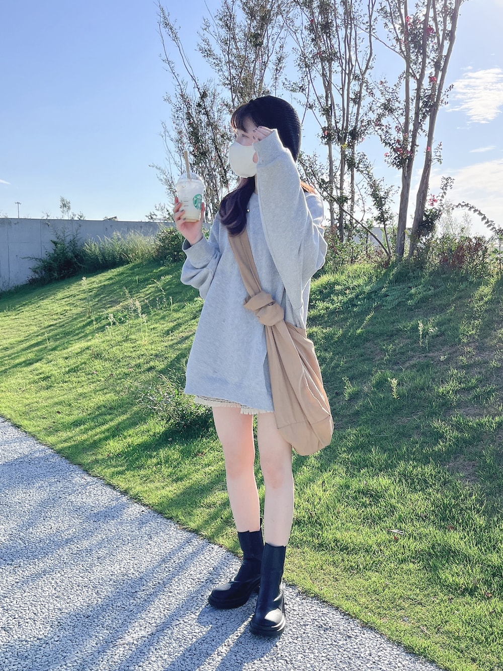 グレー系のスウェット、ベージュ系のその他パンツ、ベージュ系のショルダーバッグを着用したレディースの秋コーディネートの2枚目の写真