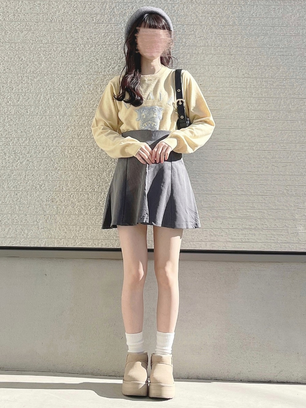 イエロー系のニット/セーターを着用したレディースの冬コーディネートの2枚目の写真