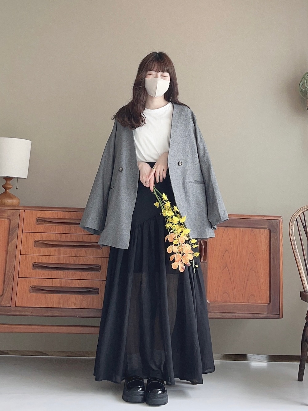 ホワイト系のカーディガン/ボレロ、ブラック系のスカート、ベージュ系のショルダーバッグを着用したレディースの春コーディネートの2枚目の写真