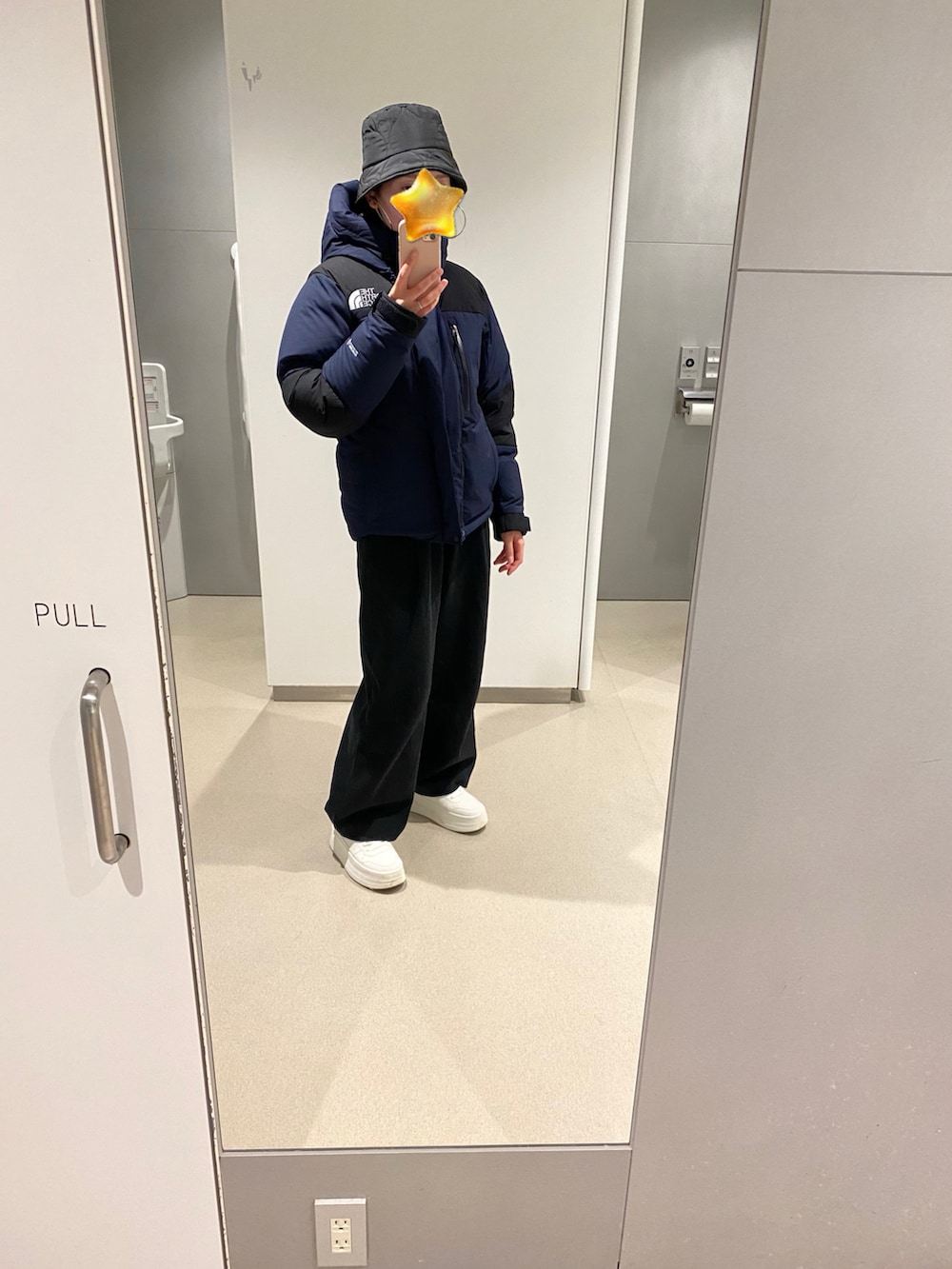 ブルー系のダウンジャケット/コート、ブラック系のパンツ、ホワイト系のスニーカーを着用したレディースの冬コーディネートの2枚目の写真