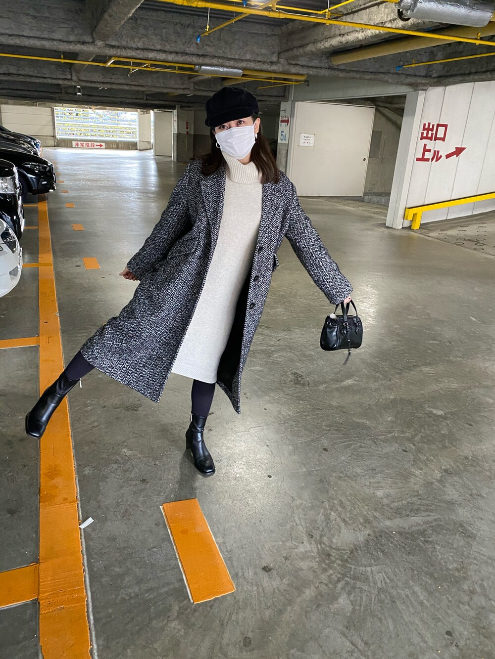 ホワイト系のワンピース、ブラック系のハンドバッグ、ブラック系のブーツを着用したレディースの春コーディネートの2枚目の写真