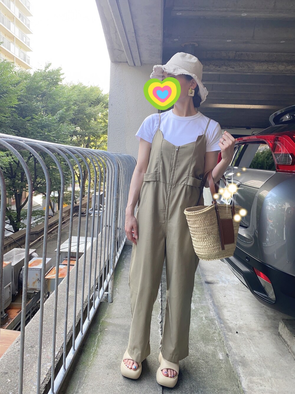 ホワイト系のTシャツ/カットソー、ベージュ系のかごバッグ、ベージュ系のサロペット/オーバーオールを着用したレディースの夏コーディネートの2枚目の写真