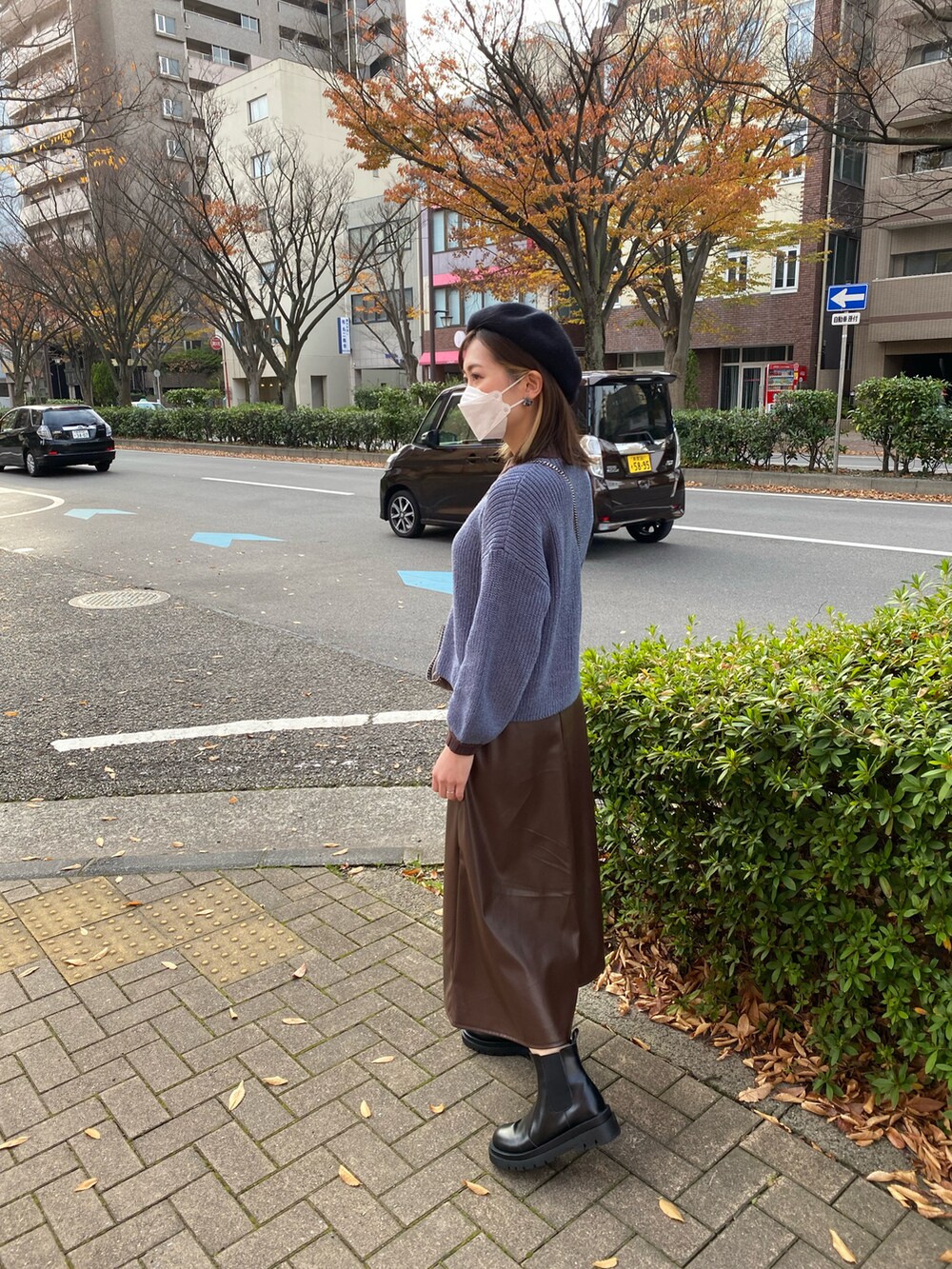 ブルー系のニット/セーター、ブラウン系のスカート、ブラック系のブーツを着用したレディースの春コーディネートの2枚目の写真