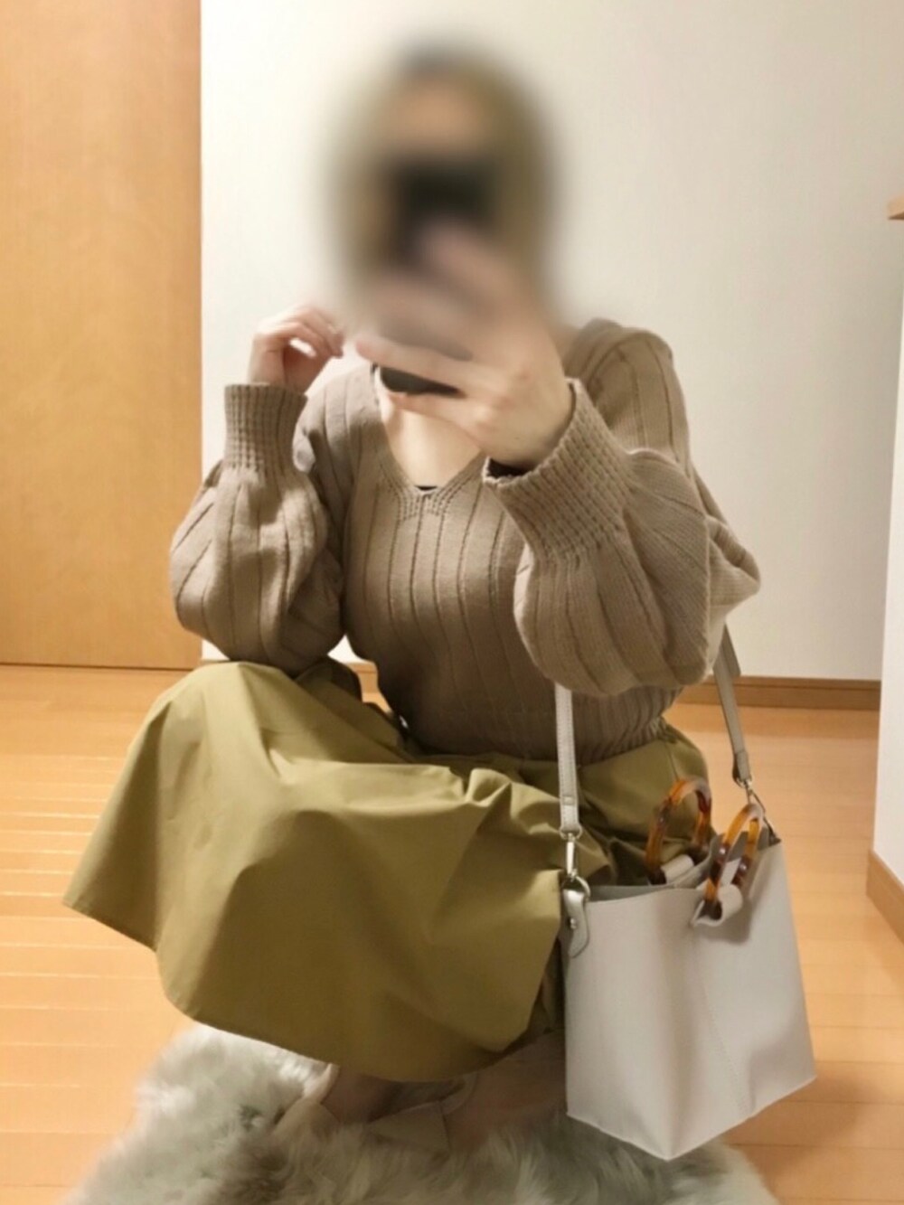 ベージュ系のニット/セーター、ベージュ系のスカート、ベージュ系のショルダーバッグを着用したレディースの夏コーディネートの3枚目の写真