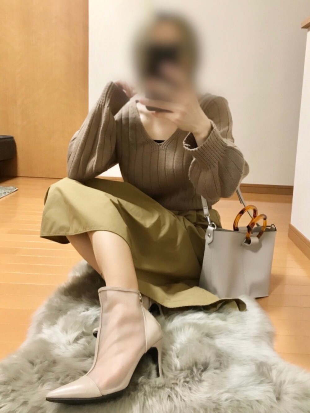 ベージュ系のニット/セーター、ベージュ系のスカート、ベージュ系のショルダーバッグを着用したレディースの夏コーディネートの2枚目の写真