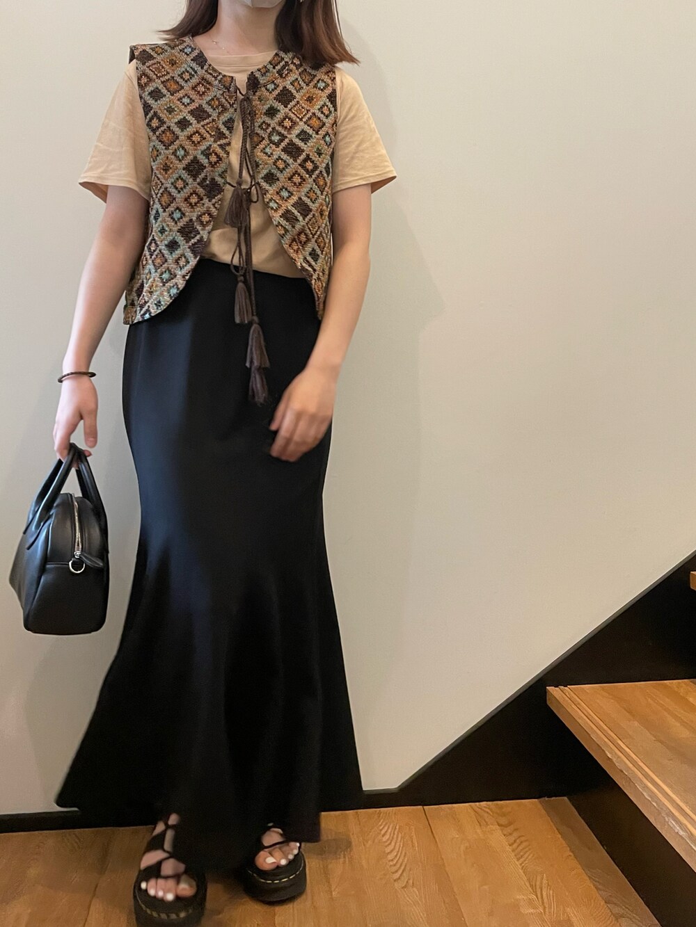 ブラウン系のベスト、ブラック系のサンダルを着用したレディースの夏コーディネートの2枚目の写真