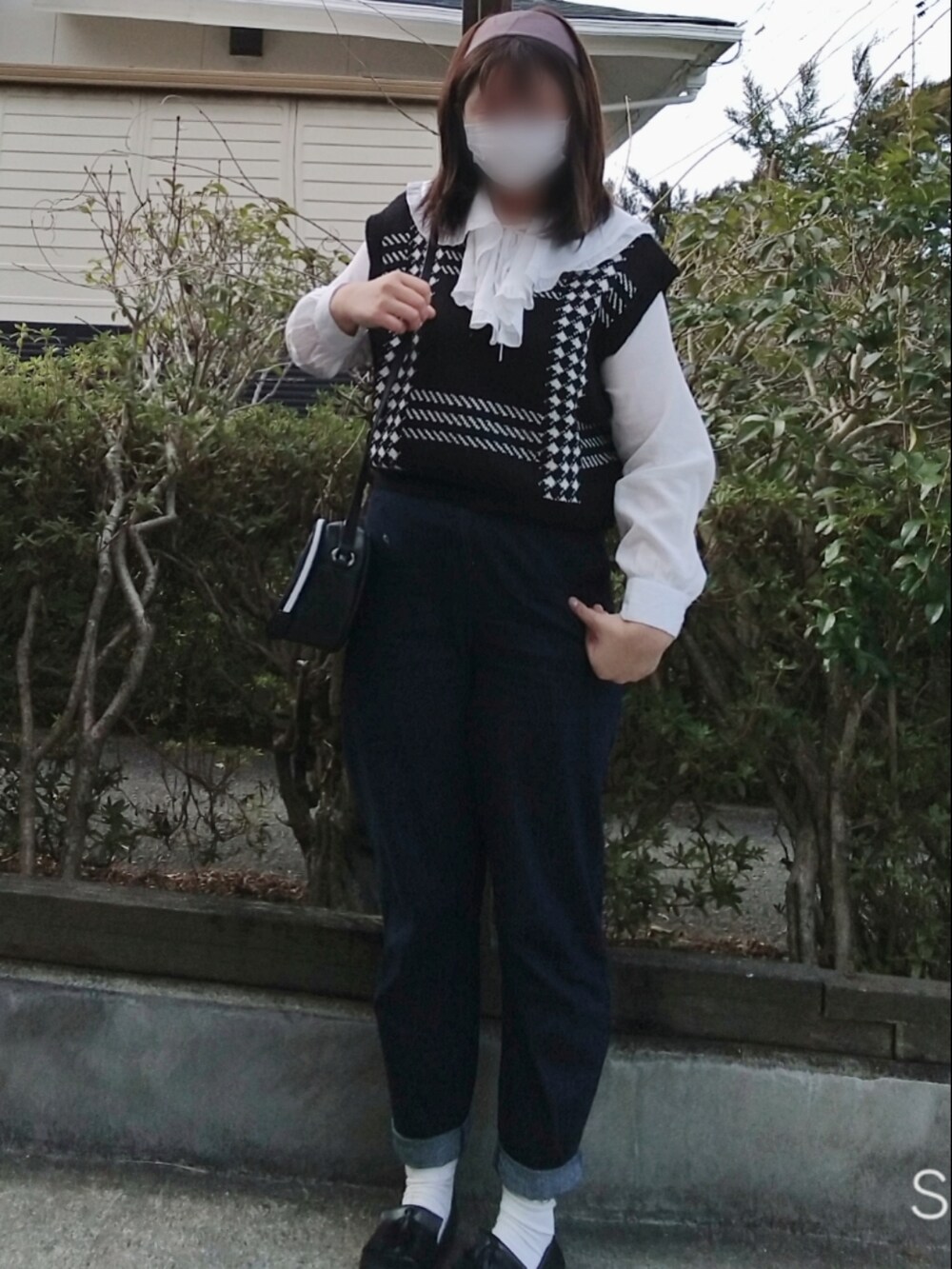 ブラック系のローファー、ブルー系のデニムパンツ、ブラック系のショルダーバッグを着用したレディースの春コーディネートの2枚目の写真