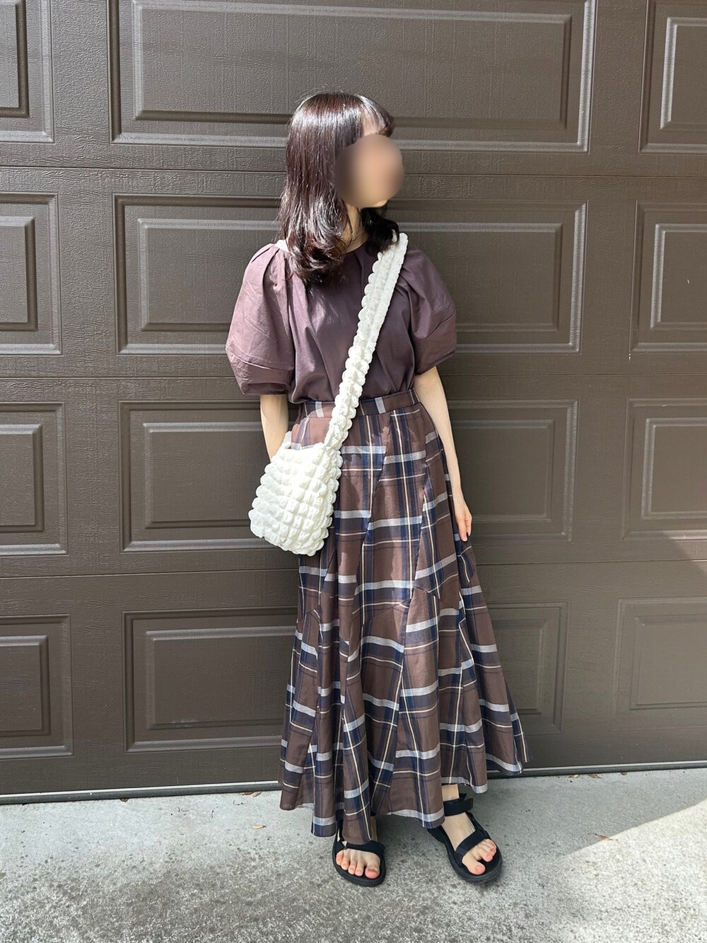 ブラウン系のスカート、ブラック系のサンダルを着用したレディースの秋コーディネートの2枚目の写真