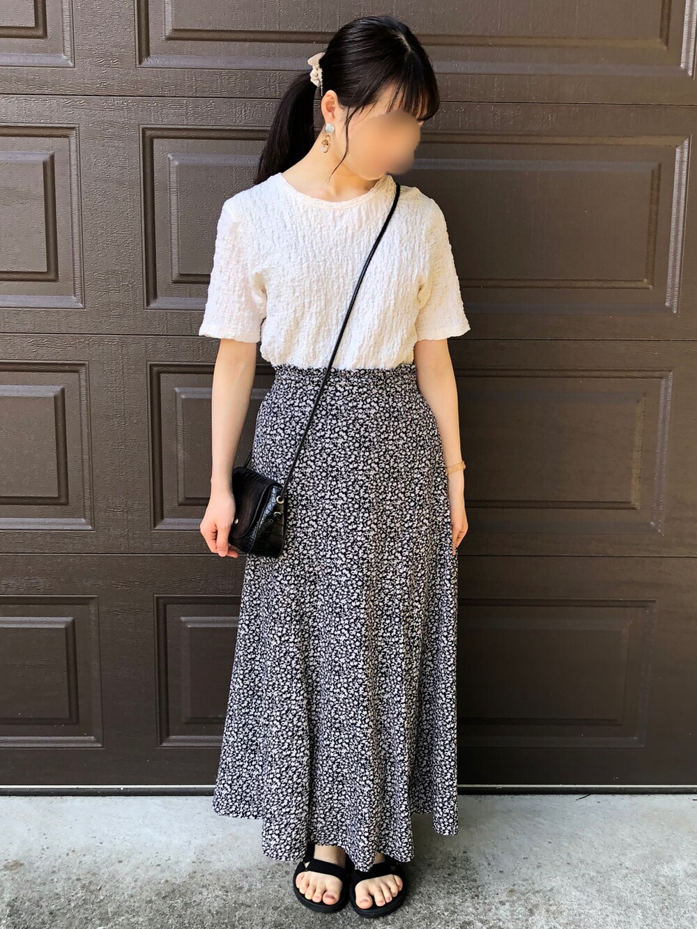 ホワイト系のTシャツ/カットソー、ブラック系のスカート、ブラック系のショルダーバッグを着用したレディースの夏コーディネートの2枚目の写真