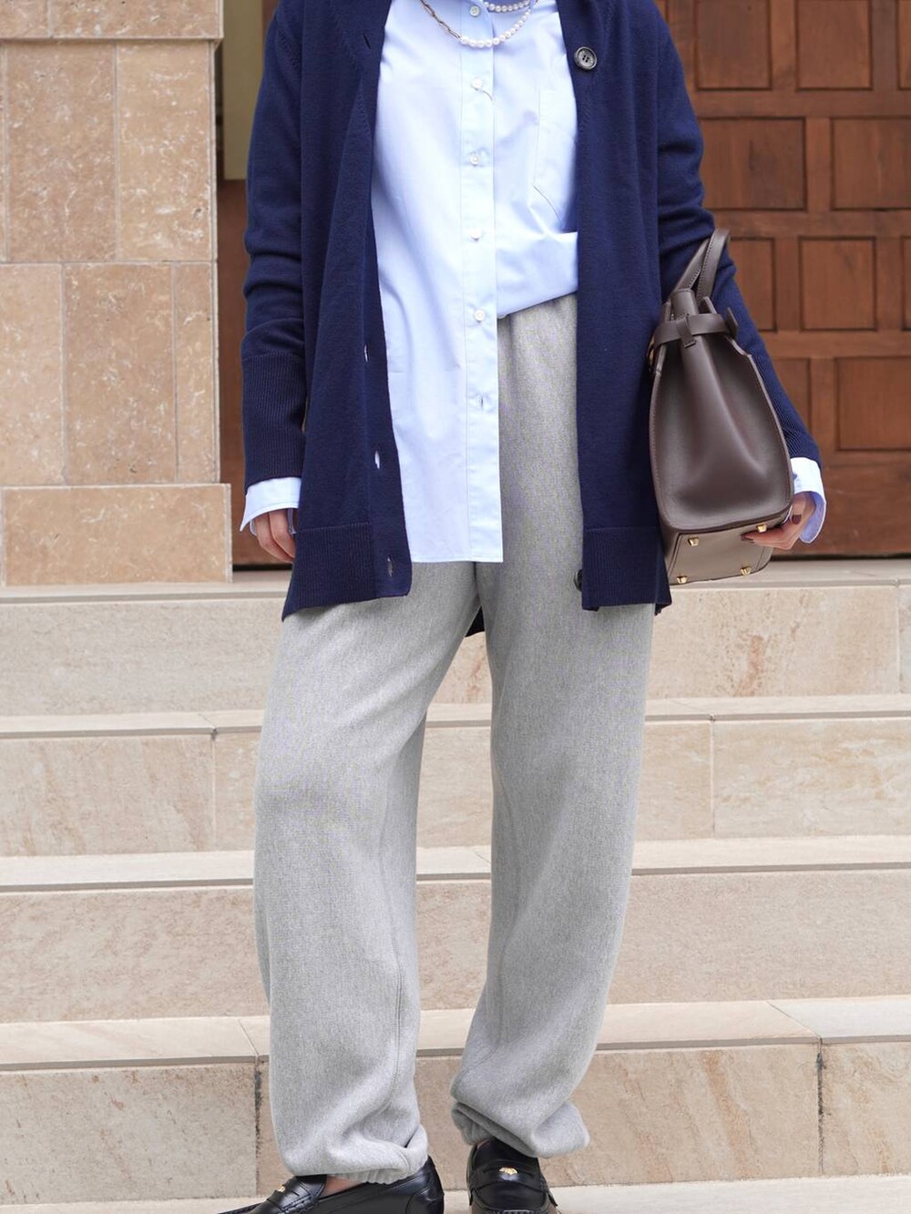 ブラック系のローファー、グレー系のスウェットパンツ、ブルー系のシャツ/ブラウスを着用したレディースの秋コーディネートの2枚目の写真