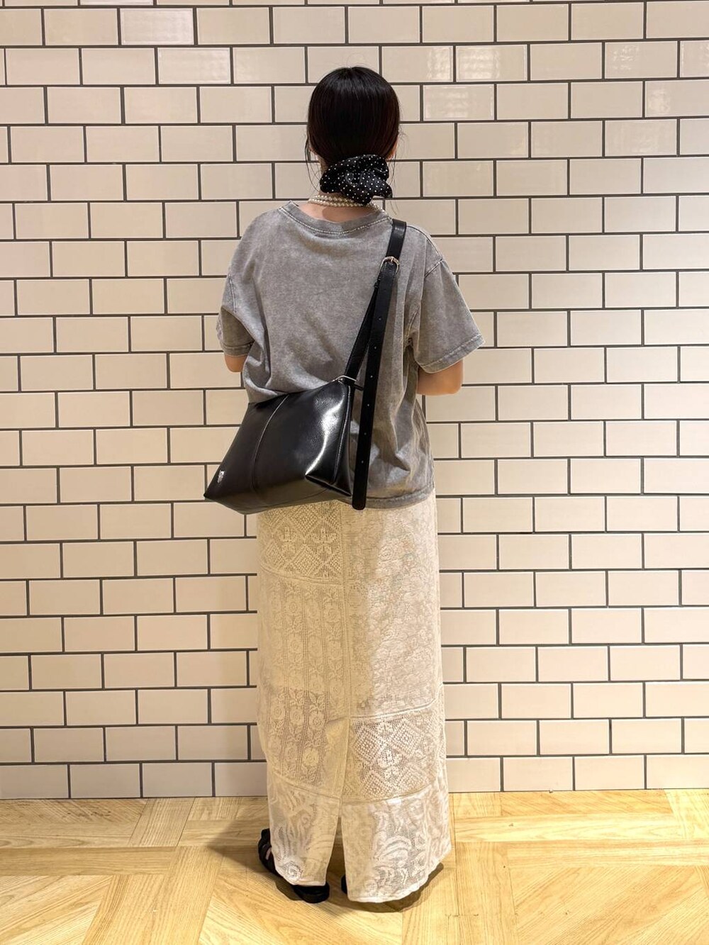 ブラック系のショルダーバッグ、ホワイト系のスカート、ブラック系のサンダルを着用したレディースの夏コーディネートの4枚目の写真