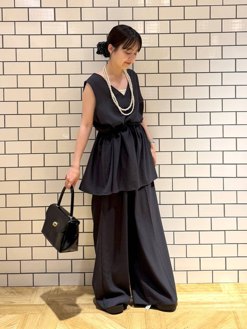 ホワイト系のキャミソール、ブラック系のサンダル、グレー系のサロペット/オーバーオールを着用したレディースの夏コーディネートの2枚目の写真