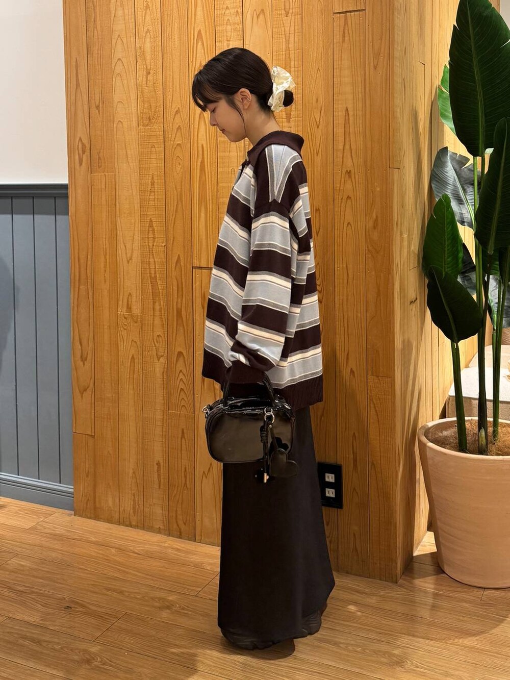 ブラック系のスカート、ブラウン系のニット/セーター、ブラック系のボストンバッグを着用したレディースの秋コーディネートの3枚目の写真