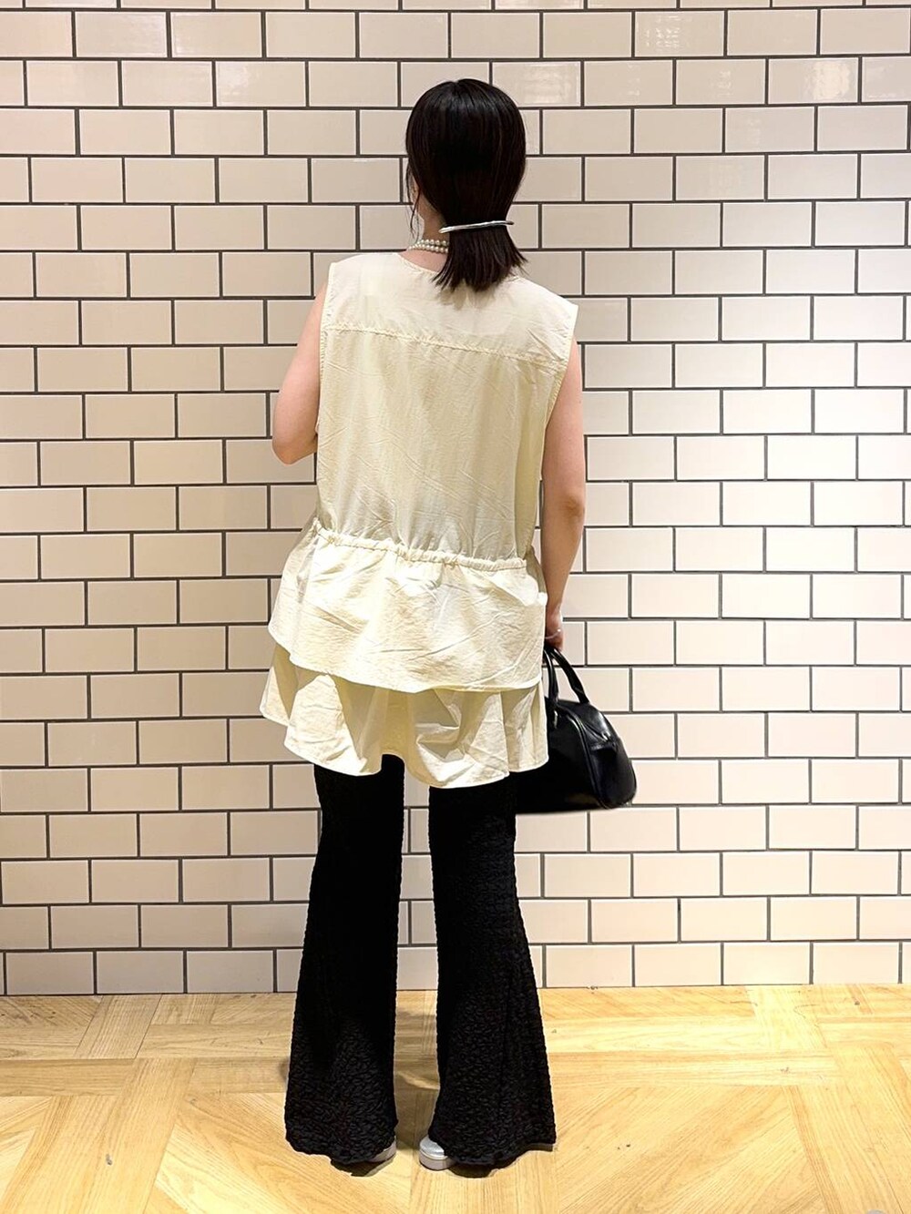 シルバー系のサンダル、シルバー系のタンクトップ、ブラック系のその他パンツを着用したレディースの夏コーディネートの4枚目の写真