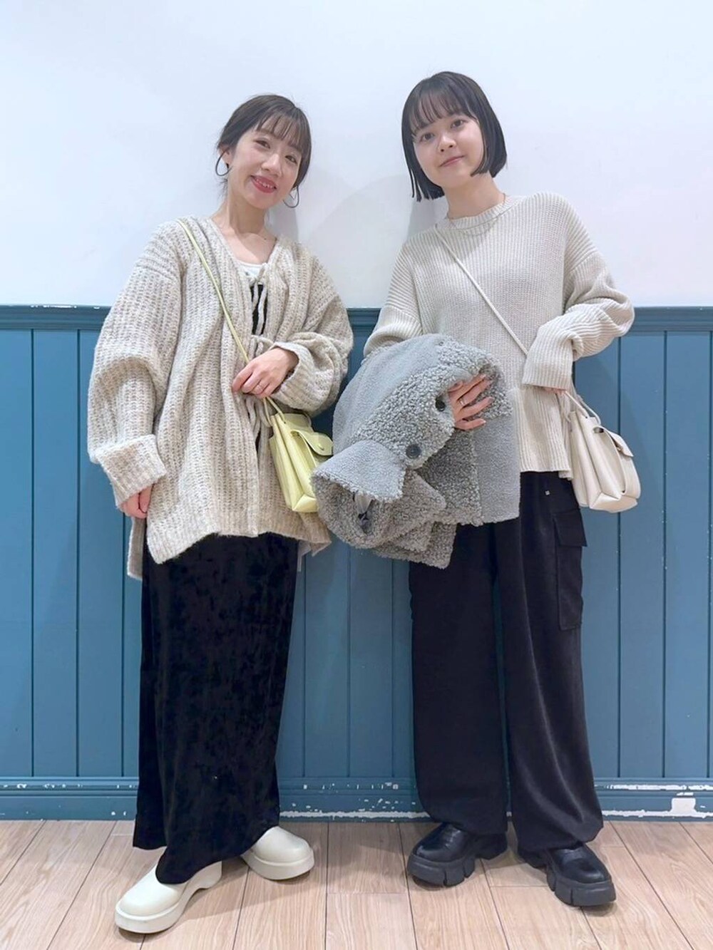 ホワイト系のショルダーバッグ、ブラック系のブーツ、ブラック系のワンピースを着用したレディースの冬コーディネートの3枚目の写真