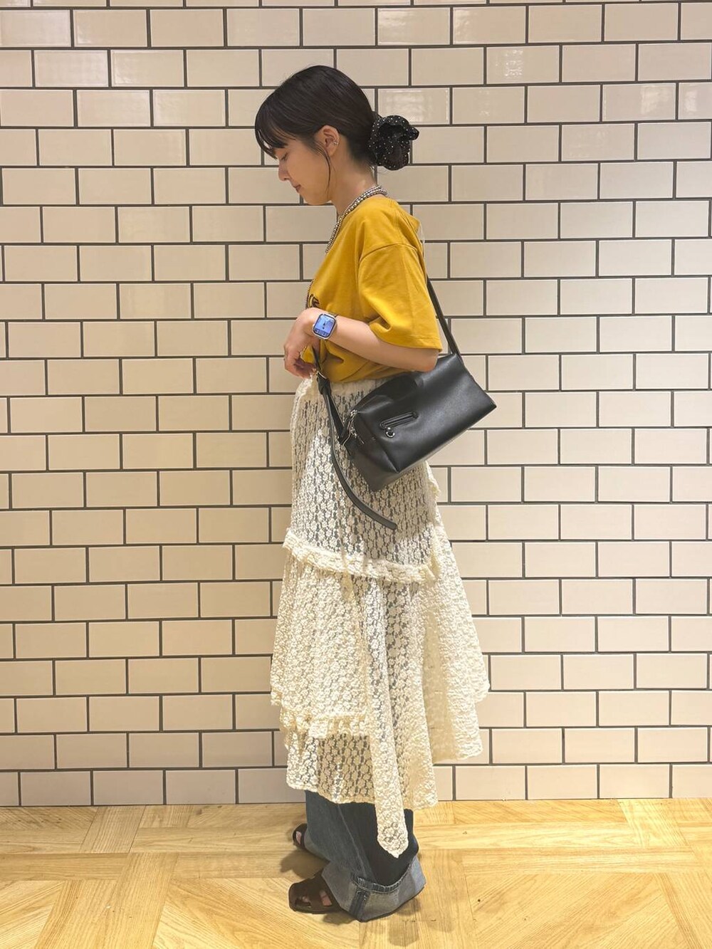 ブラウン系のサンダル、ブルー系のデニムパンツ、ホワイト系のスカートを着用したレディースの夏コーディネートの3枚目の写真