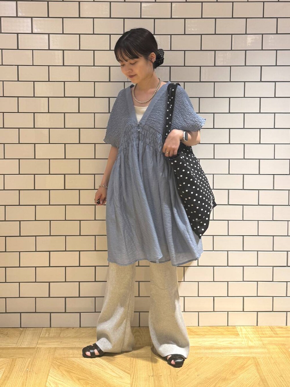 ホワイト系のキャミソール、その他のトートバッグ、ブラック系のサンダルを着用したレディースの夏コーディネートの2枚目の写真