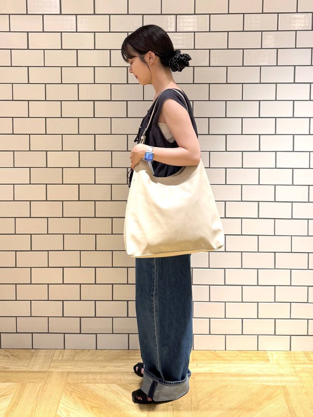 ホワイト系のショルダーバッグ、ホワイト系のキャミソール、ブラック系のサンダルを着用したレディースの夏コーディネートの3枚目の写真