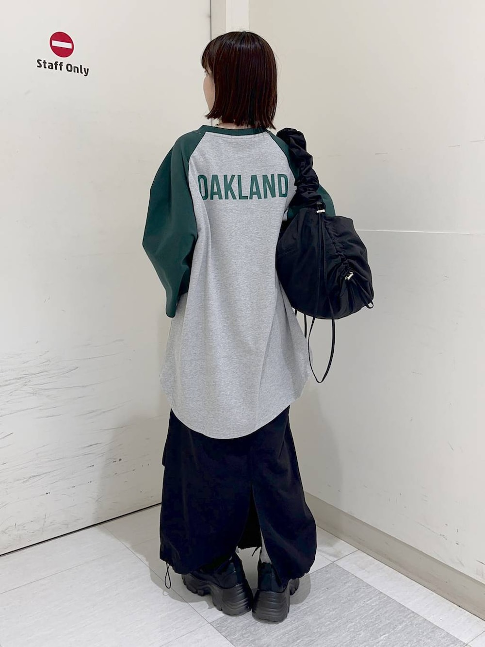 グリーン系のTシャツ/カットソー、ブラック系のショルダーバッグ、グレー系のスウェットを着用したレディースの冬コーディネートの4枚目の写真