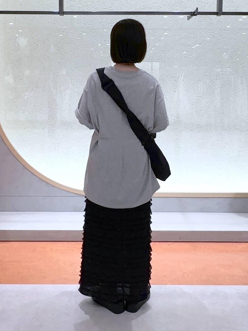 ブラック系のスカート、ブラック系のショルダーバッグ、シルバー系のサンダルを着用したレディースの夏コーディネートの4枚目の写真