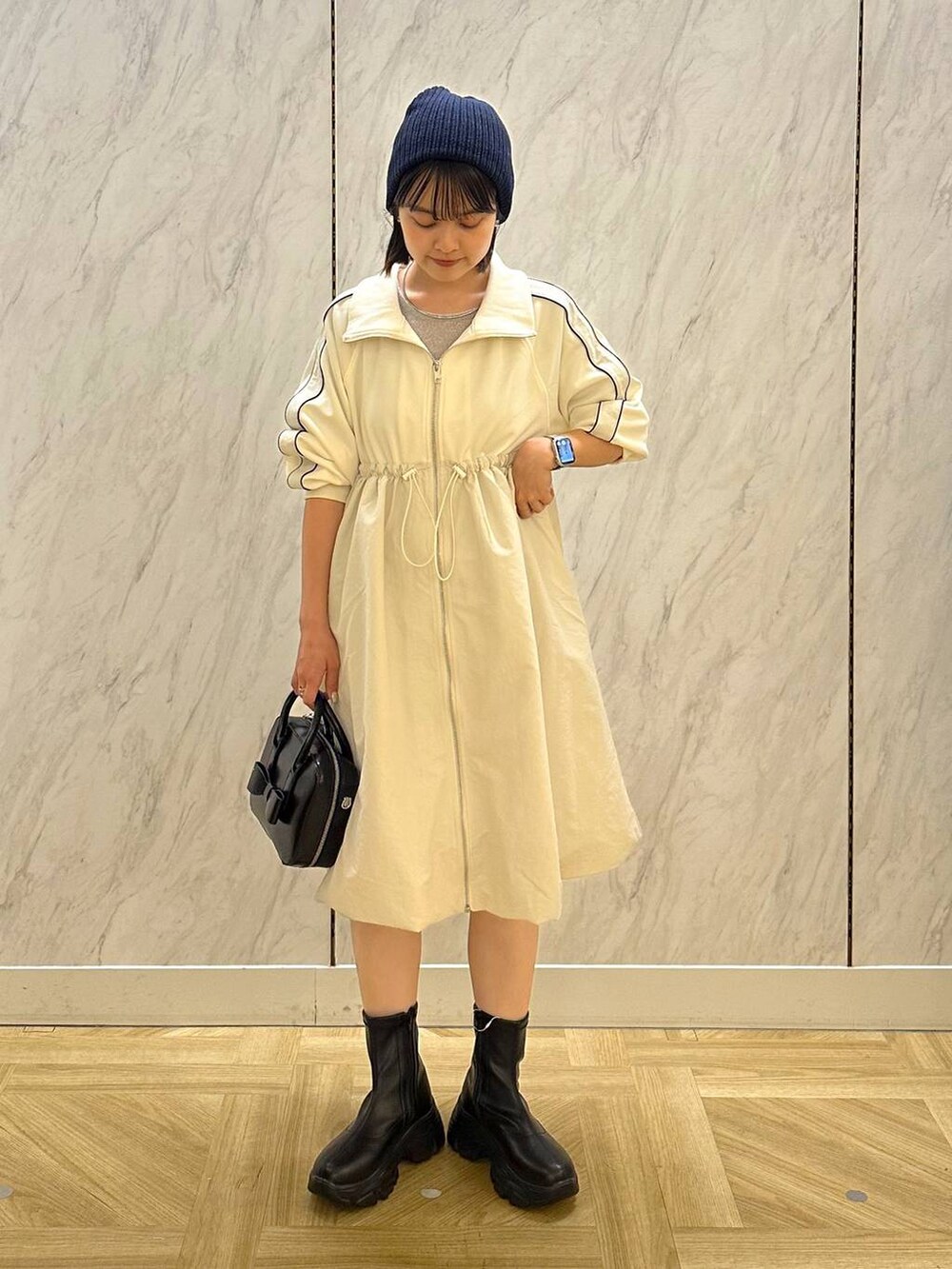 シルバー系のTシャツ/カットソー、ブラック系のボストンバッグ、ブラック系のブーツを着用したレディースの秋コーディネートの3枚目の写真