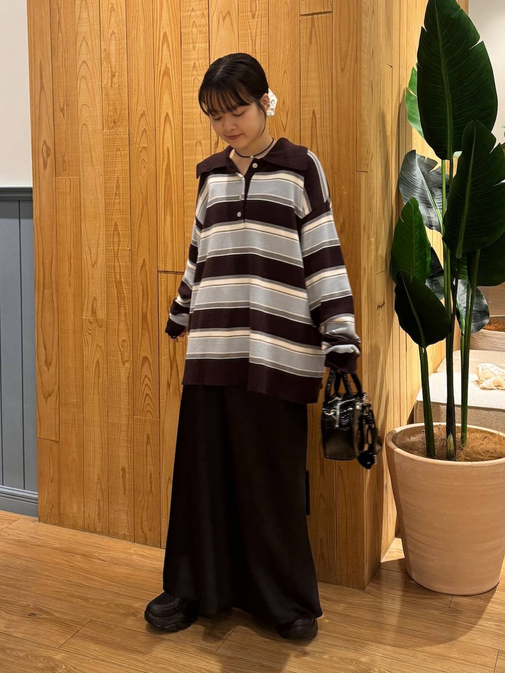 ブラック系のスカート、ブラウン系のニット/セーター、ブラック系のボストンバッグを着用したレディースの秋コーディネートの2枚目の写真