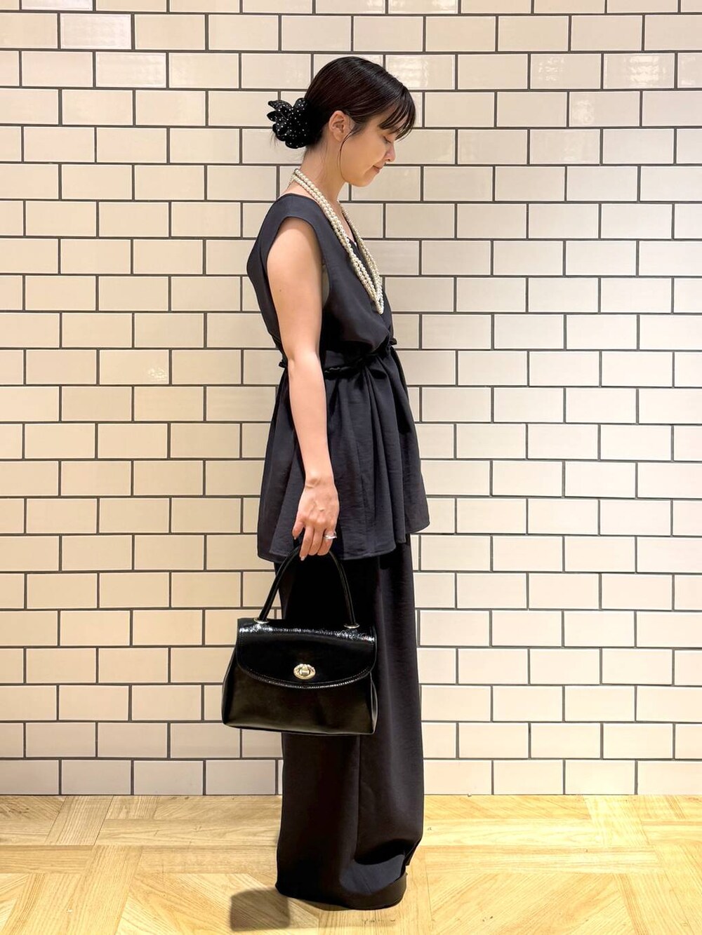 ホワイト系のキャミソール、ブラック系のサンダル、グレー系のサロペット/オーバーオールを着用したレディースの夏コーディネートの3枚目の写真