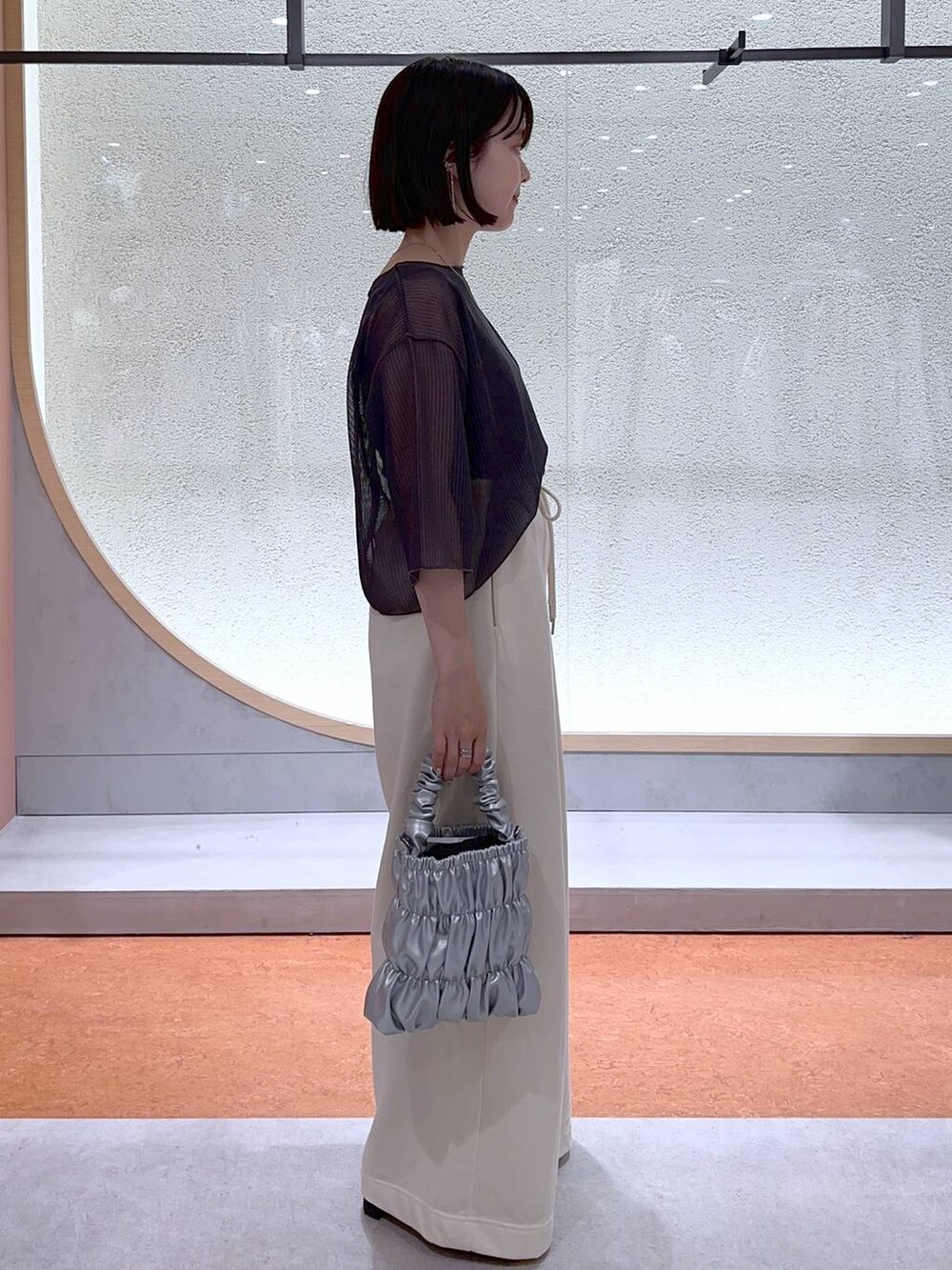 ブラック系のサンダル、ホワイト系のスウェットパンツ、グレー系のTシャツ/カットソーを着用したレディースの夏コーディネートの2枚目の写真