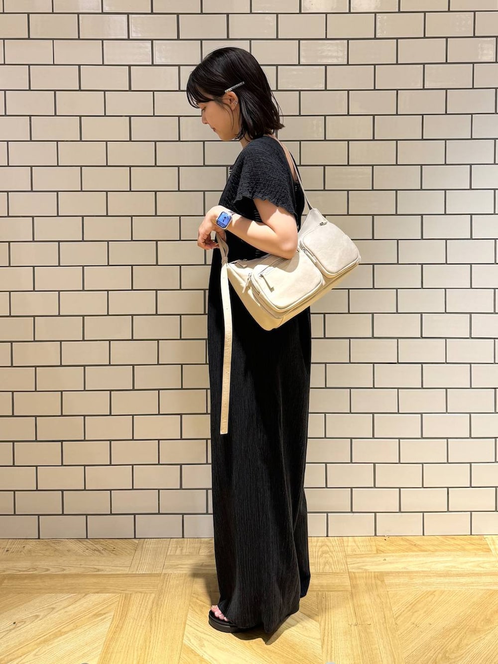 シルバー系のサンダル、ブラック系のサロペット/オーバーオール、ホワイト系のショルダーバッグを着用したレディースの夏コーディネートの4枚目の写真
