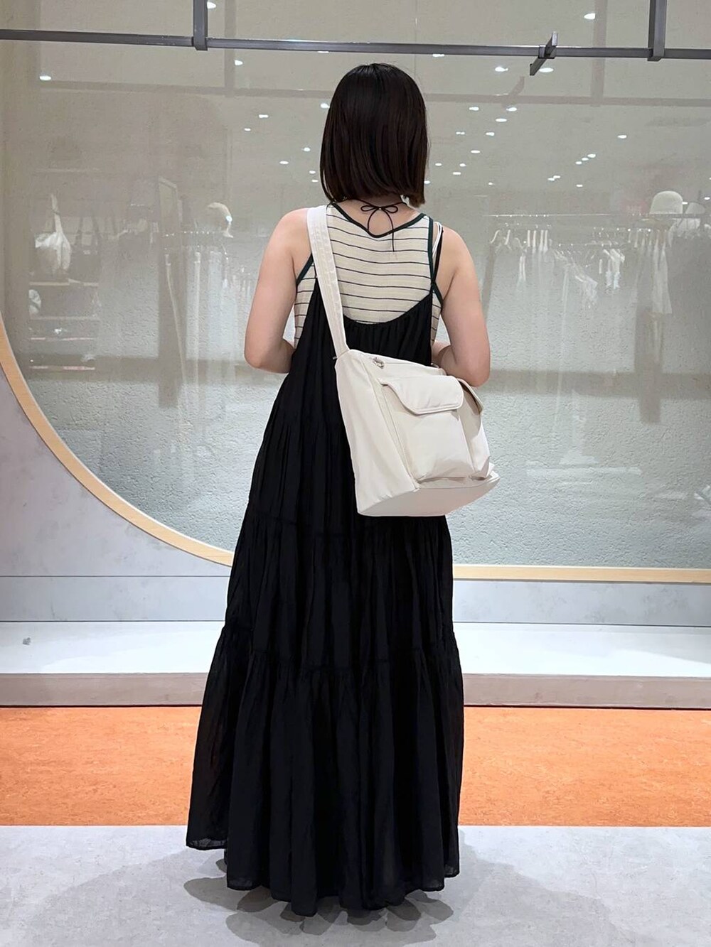 ベージュ系のタンクトップ、ホワイト系のTシャツ/カットソー、ブラック系のサンダルを着用したレディースの夏コーディネートの3枚目の写真