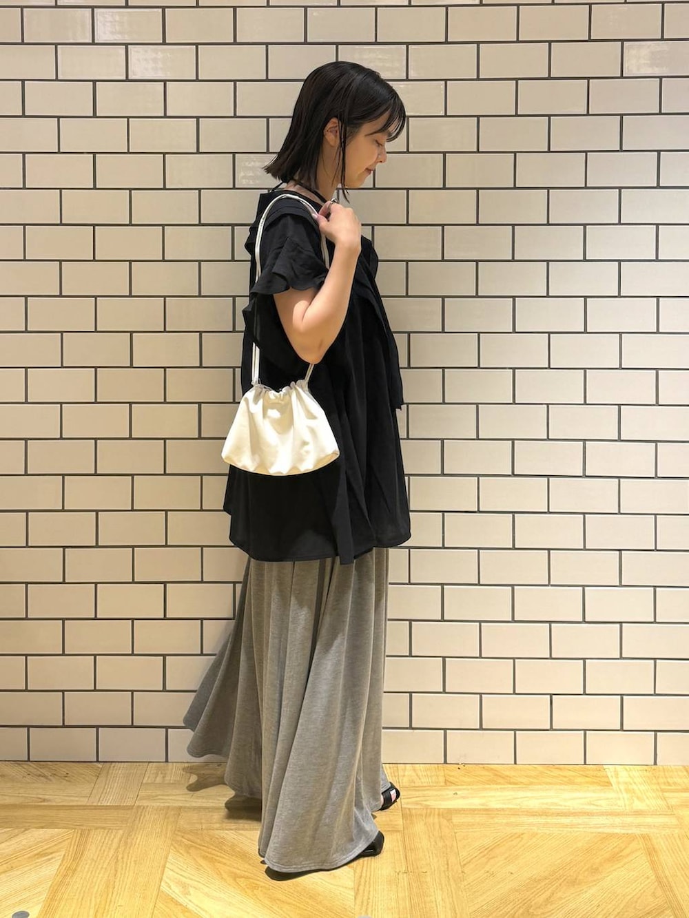 ホワイト系のショルダーバッグ、ブラック系のシャツ/ブラウス、ブラック系のサンダルを着用したレディースの夏コーディネートの3枚目の写真