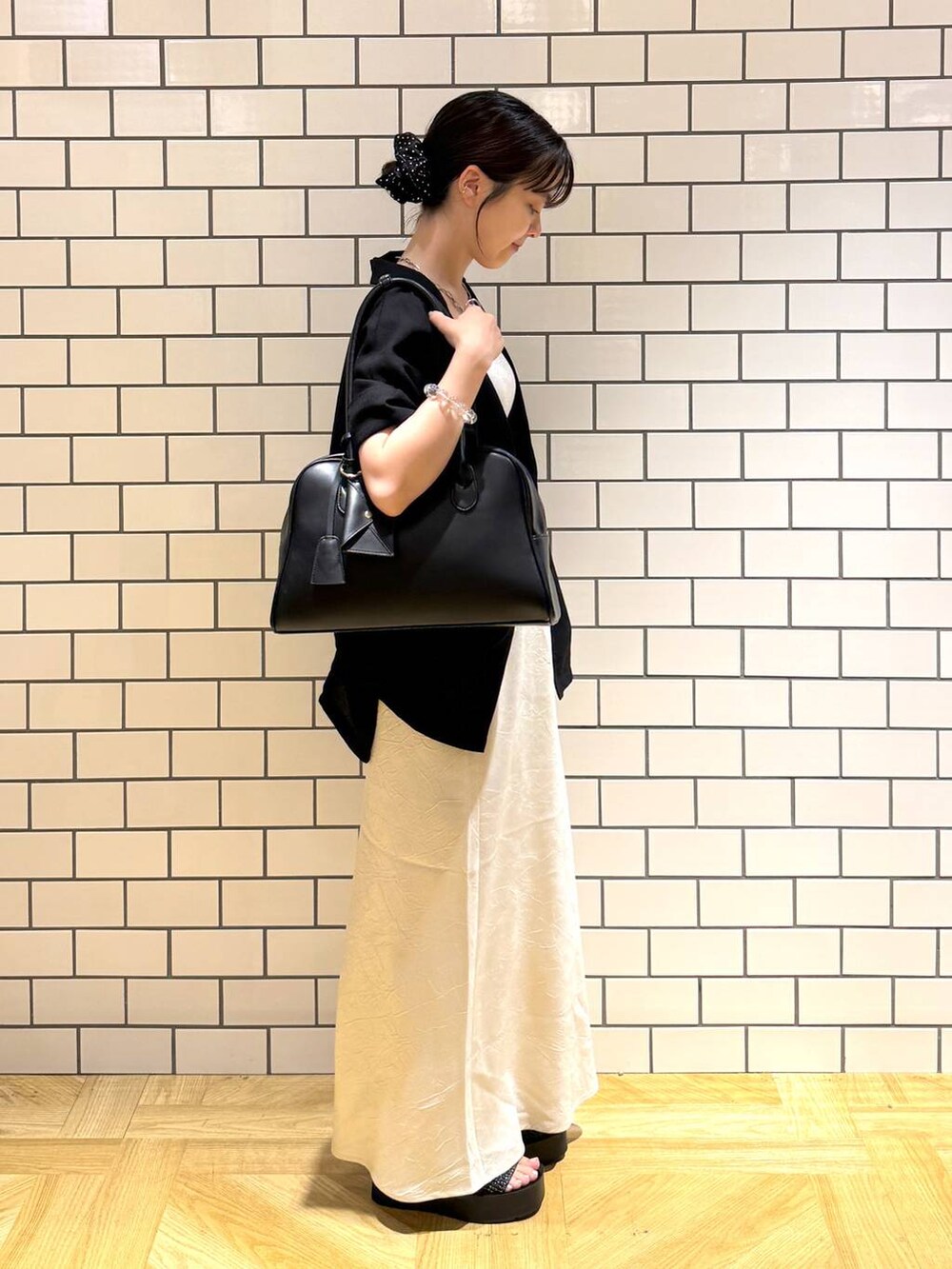 ブラック系のサンダル、ホワイト系のスカート、シルバー系のタンクトップを着用したレディースの夏コーディネートの3枚目の写真