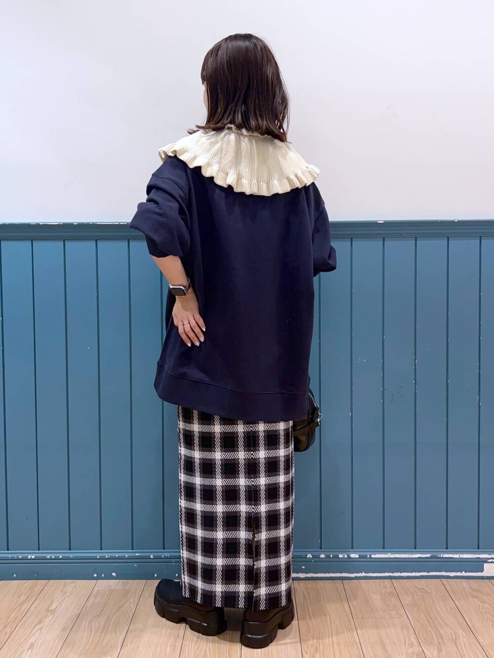 ブラック系のブーツ、ブルー系のスウェット、ブラック系のスカートを着用したレディースの秋コーディネートの3枚目の写真