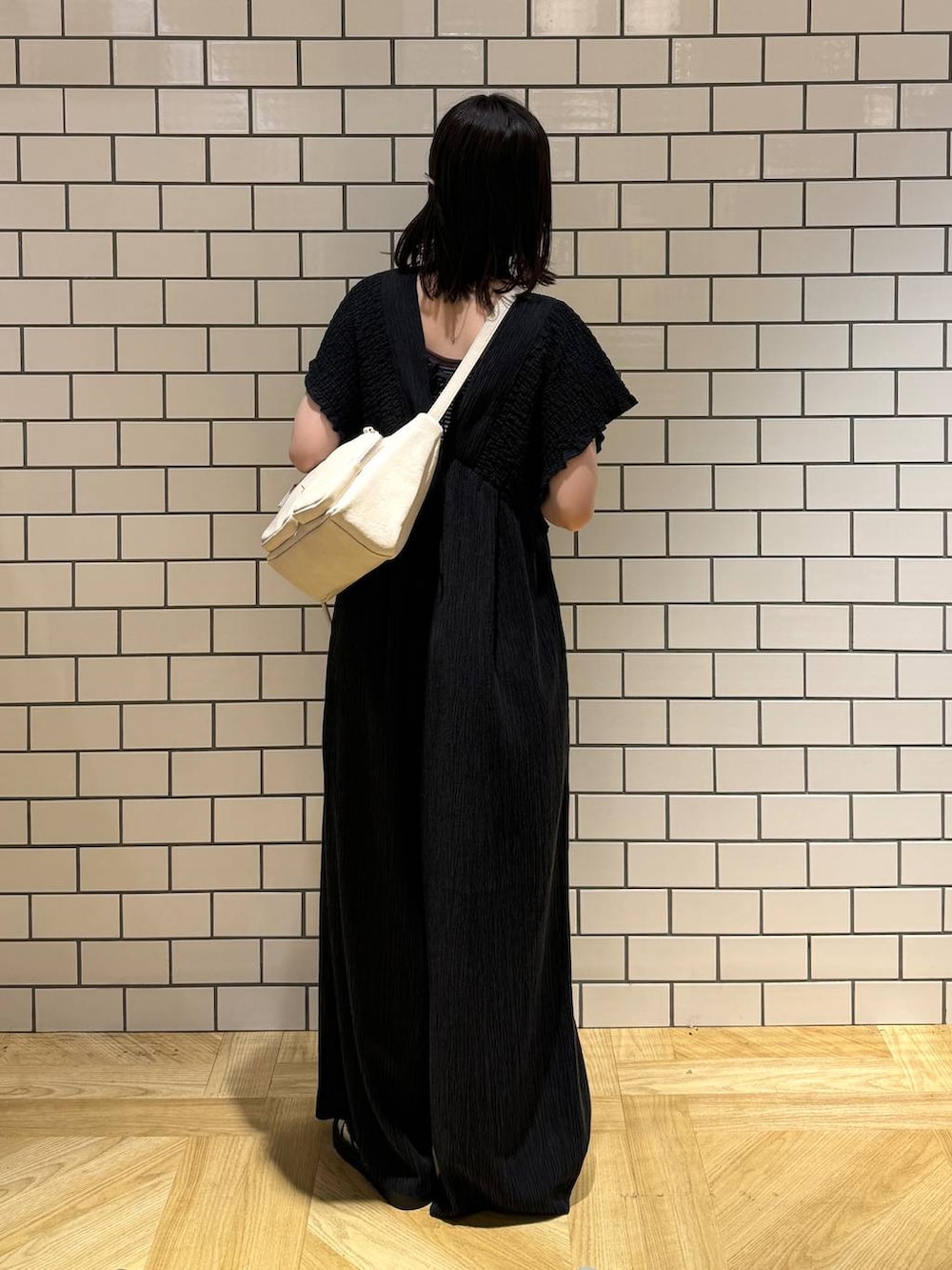 シルバー系のサンダル、ブラック系のサロペット/オーバーオール、ホワイト系のショルダーバッグを着用したレディースの夏コーディネートの5枚目の写真