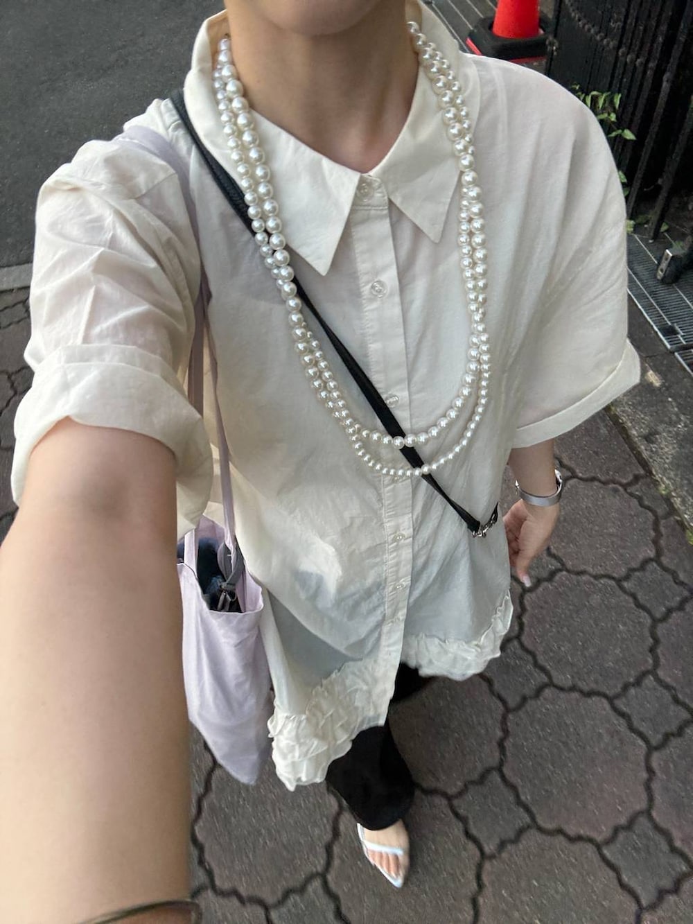 シルバー系のサンダル、ブラック系のスカート、ホワイト系のシャツ/ブラウスを着用したレディースの夏コーディネートの2枚目の写真