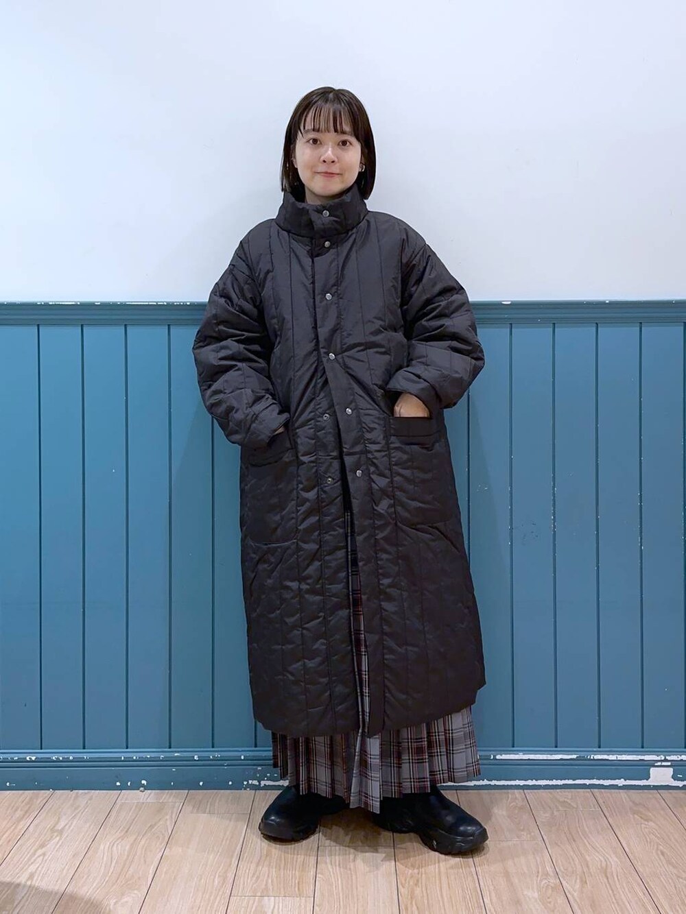 ホワイト系のショルダーバッグ、ブラック系のブーツ、ブラック系のミリタリージャケットを着用したレディースの冬コーディネートの4枚目の写真