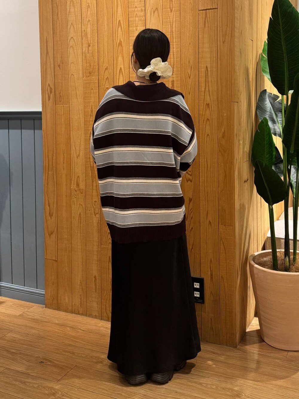 ブラック系のスカート、ブラウン系のニット/セーター、ブラック系のボストンバッグを着用したレディースの秋コーディネートの4枚目の写真