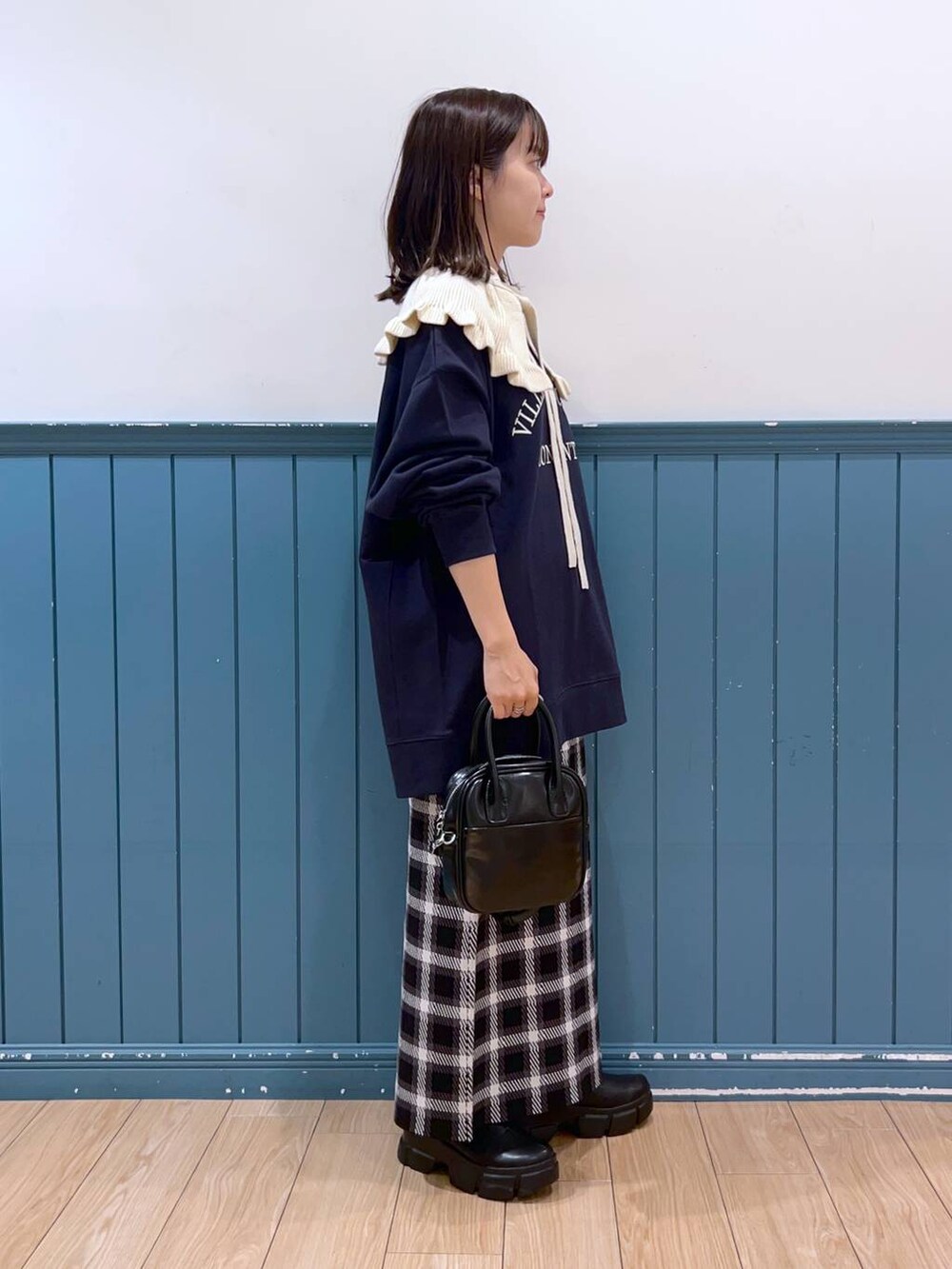 ブラック系のブーツ、ブルー系のスウェット、ブラック系のスカートを着用したレディースの秋コーディネートの2枚目の写真