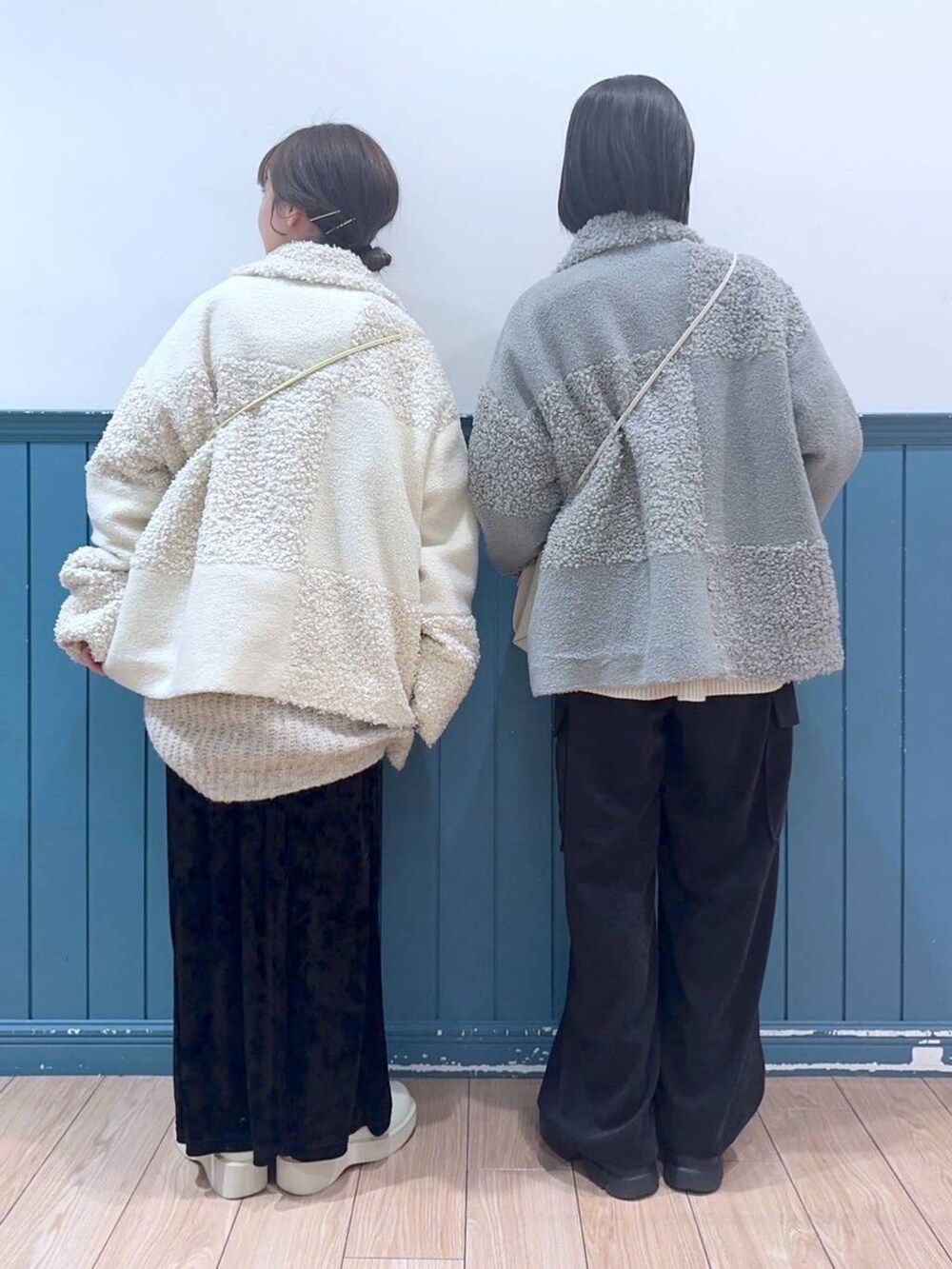 ホワイト系のショルダーバッグ、ブラック系のブーツ、ブラック系のワンピースを着用したレディースの冬コーディネートの2枚目の写真