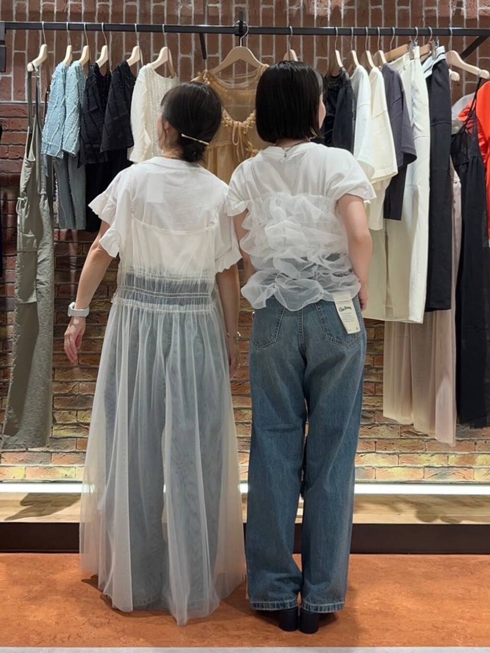 ブラック系のサンダル、ブルー系のデニムパンツ、ホワイト系のスニーカーを着用したレディースの夏コーディネートの2枚目の写真