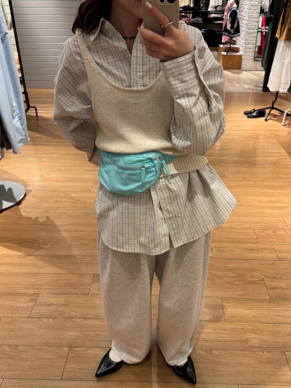 グレー系のスウェットパンツ、ブラック系のパンプス、ブルー系のボディバッグ/ウエストポーチを着用したレディースの春コーディネートの2枚目の写真