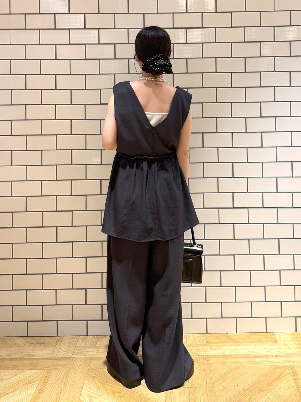 ホワイト系のキャミソール、ブラック系のサンダル、グレー系のサロペット/オーバーオールを着用したレディースの夏コーディネートの4枚目の写真