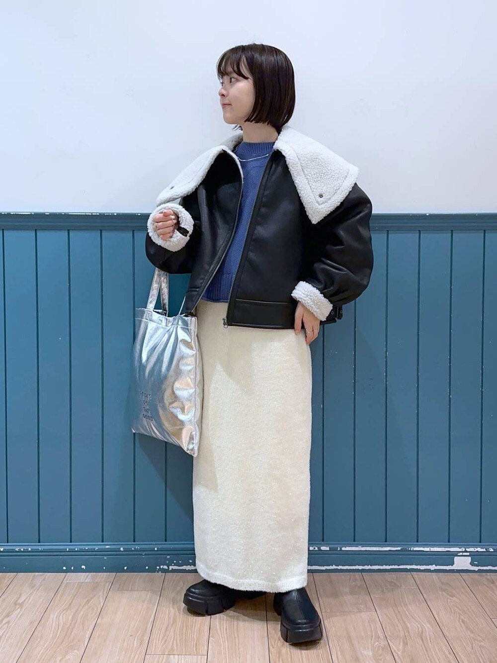 ブラック系のブーツ、シルバー系のトートバッグ、ブルー系のTシャツ/カットソーを着用したレディースの冬コーディネートの2枚目の写真