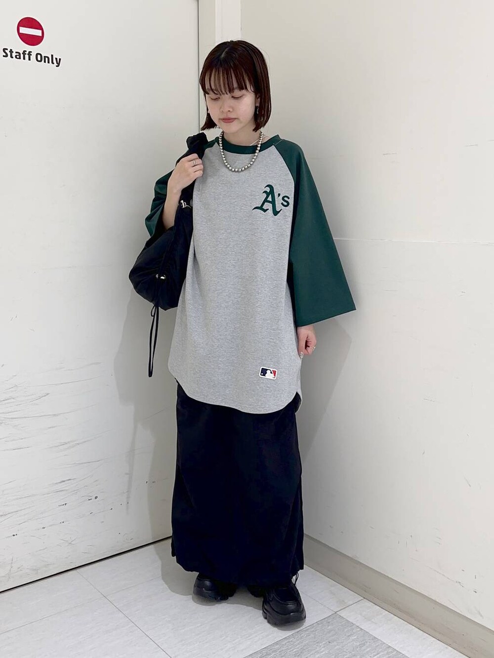 グリーン系のTシャツ/カットソー、ブラック系のショルダーバッグ、グレー系のスウェットを着用したレディースの冬コーディネートの2枚目の写真