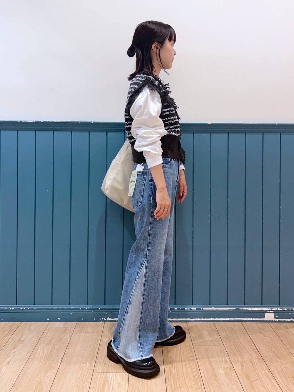 ブラック系のボディバッグ/ウエストポーチ、その他のデニムパンツ、ブラック系のベストを着用したレディースの秋コーディネートの2枚目の写真