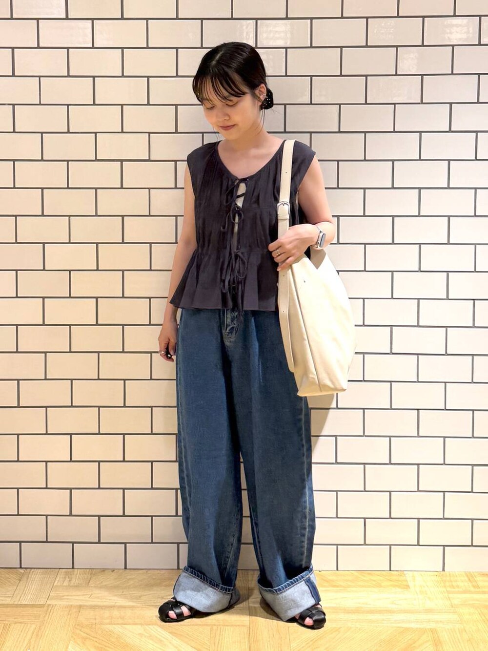 ホワイト系のショルダーバッグ、ホワイト系のキャミソール、ブラック系のサンダルを着用したレディースの夏コーディネートの2枚目の写真