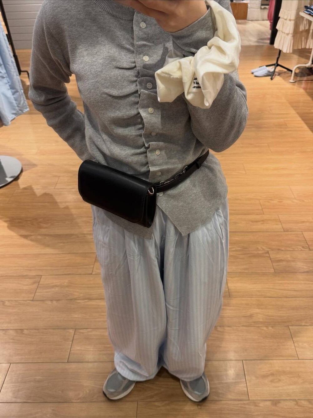 ブルー系のその他パンツ、ブラック系のボディバッグ/ウエストポーチ、グレー系のカーディガン/ボレロを着用したレディースの春コーディネートの2枚目の写真