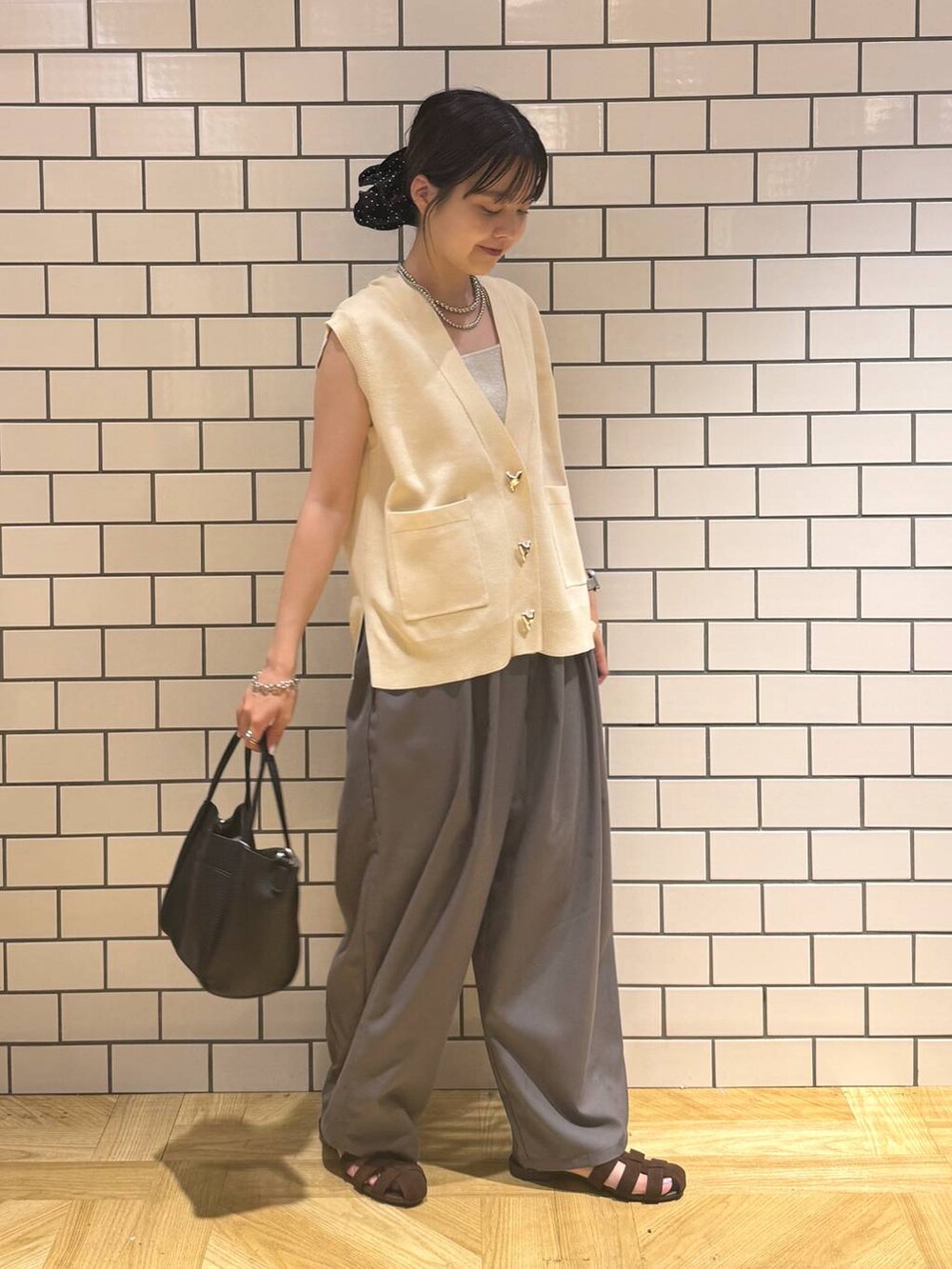 シルバー系のタンクトップ、グレー系のその他パンツ、ブラウン系のサンダルを着用したレディースの夏コーディネートの2枚目の写真